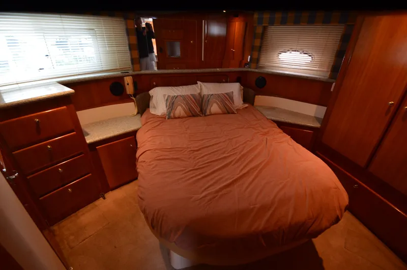 Slide: The Image of Luxurious bedroom interior of 2001 Carver 406 yacht with cozy bed and wooden cabinetry. - 25