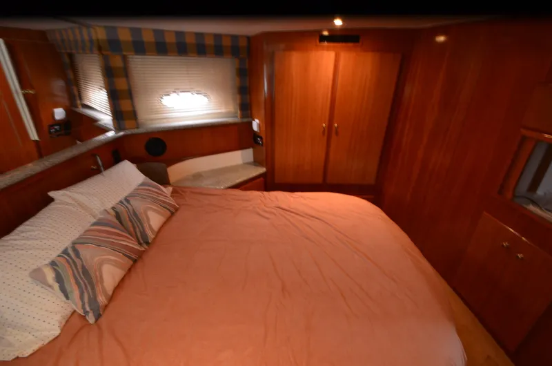 Slide: The Image of Interior of 2001 Carver 406 yacht bedroom with cozy bed and wooden cabinetry. - 26