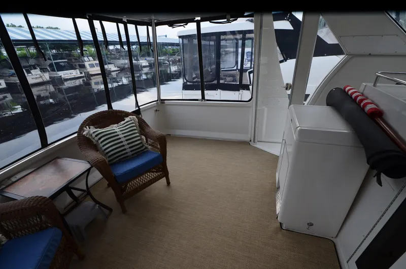 Slide: The Image of Interior view of 2001 Carver 406 yacht with wicker chairs and marina backdrop. - 3