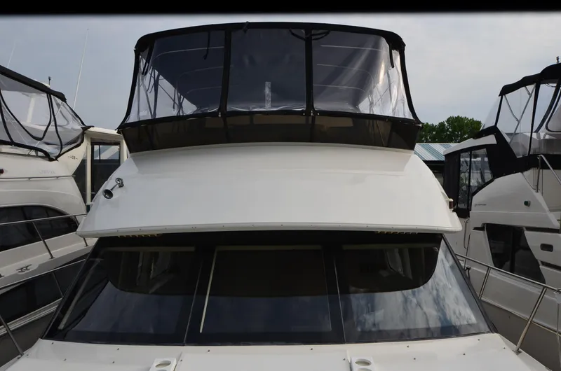 Slide: The Image of Front view of a 2001 Carver 406 yacht docked between other boats. - 41