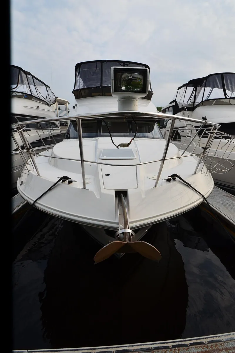 Slide: The Image of 2001 Carver 406 yacht docked, front view with sleek design and spacious deck. - 42