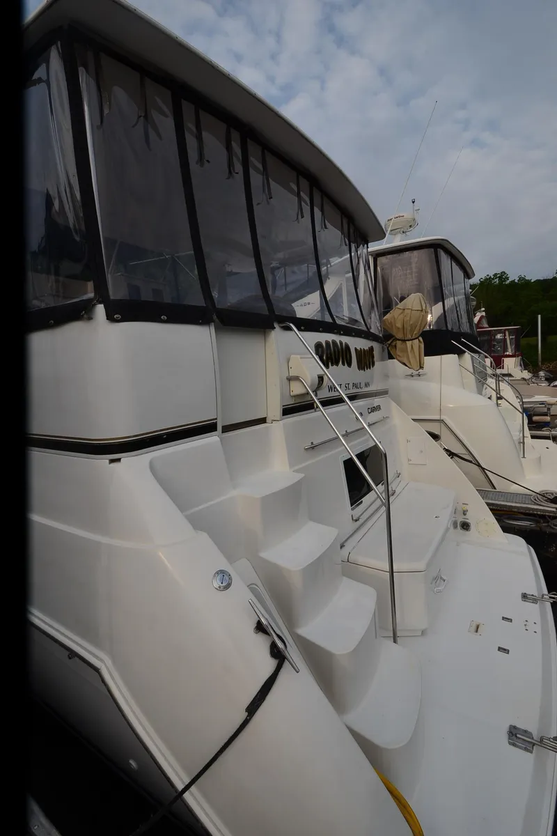 Slide: The Image of 2001 Carver 406 yacht with white exterior and covered deck, docked at marina. - 43