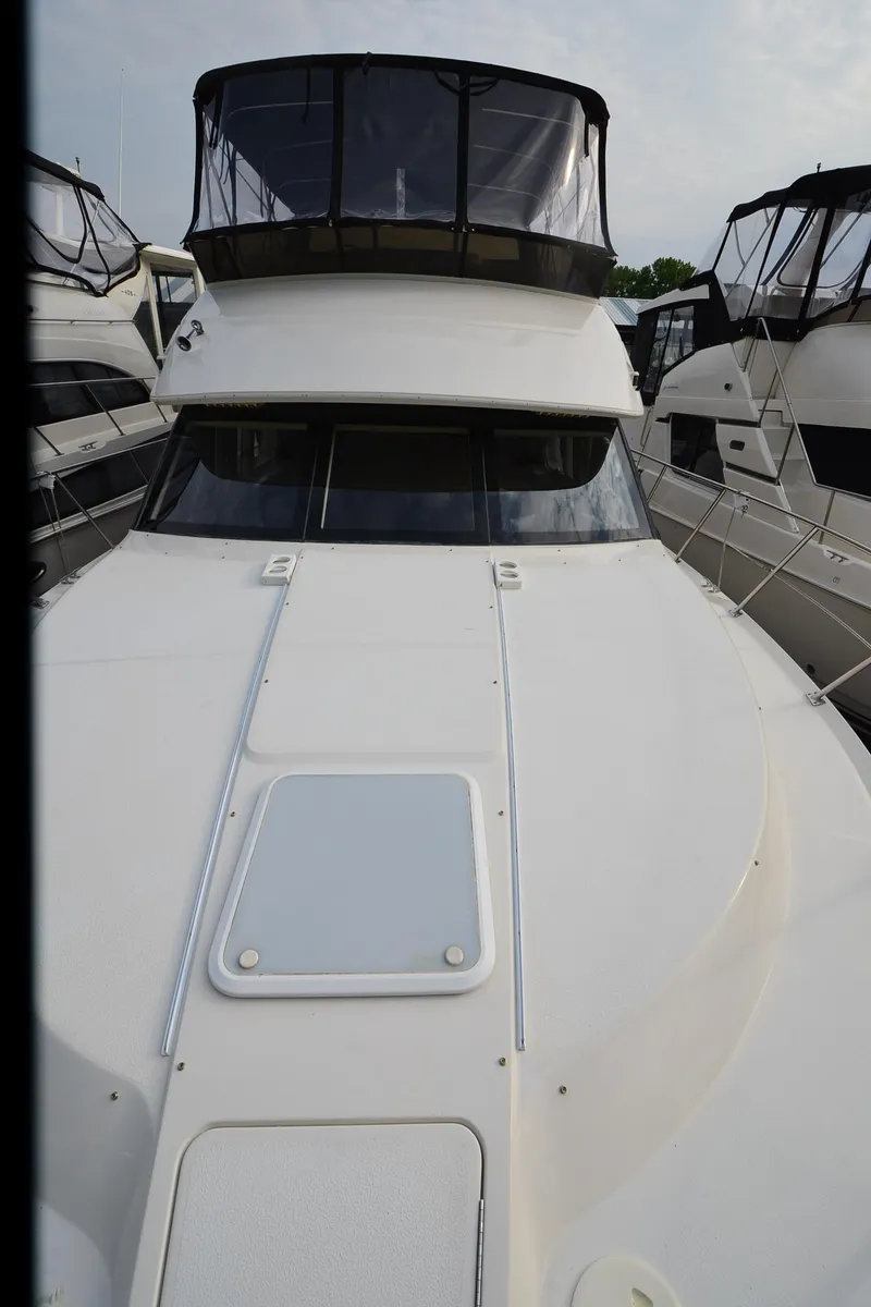 Slide: The Image of 2001 Carver 406 yacht with sleek design, docked among other boats. - 46
