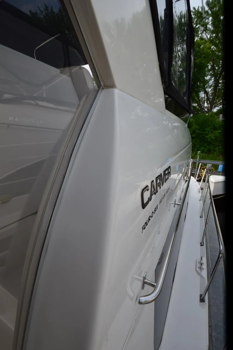 Slide: The Image of 2001 Carver 406 yacht side view with sleek design and railing details. - 47