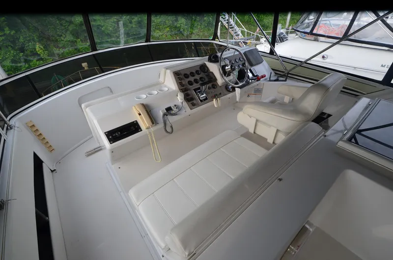 Slide: The Image of 2001 Carver 406 yacht helm with white seating and control panel. - 6