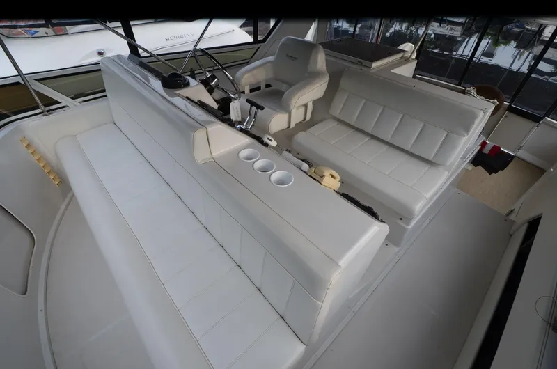 Slide: The Image of 2001 Carver 406 yacht interior with white seating and helm station. - 7