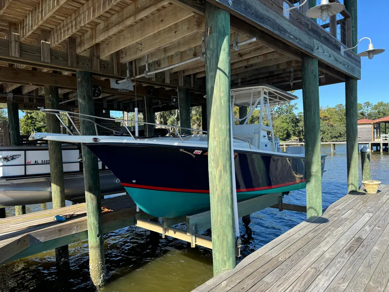 The Image of 2002 Shamrock 220 Cuddy boat docked under wooden shelter. - 0
