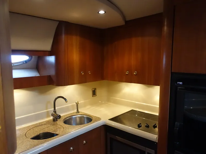 Slide: The Image of 2001 Cruisers Yachts 4270 Express kitchen with wood cabinets and modern appliances. - 11