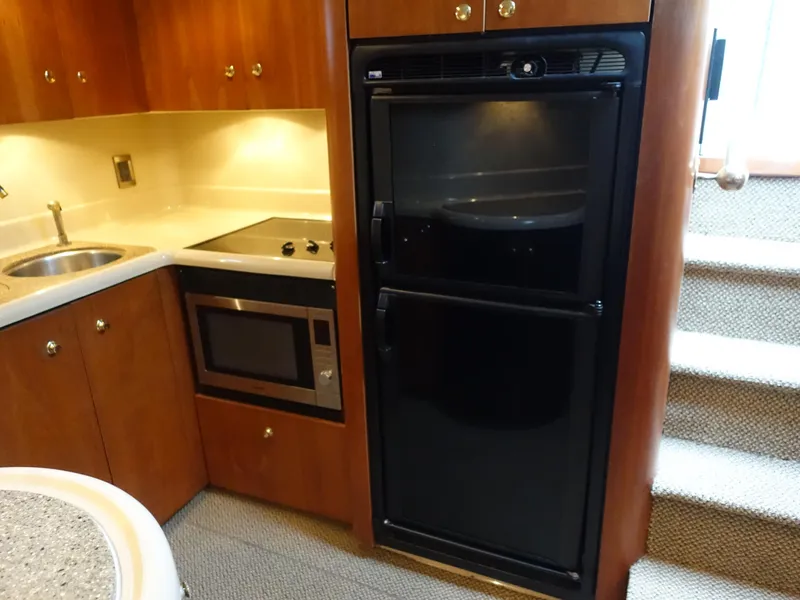 Slide: The Image of 2001 Cruisers Yachts 4270 Express kitchen with fridge, microwave, and sink. - 12