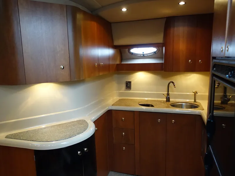 Slide: The Image of Luxurious 2001 Cruisers Yachts 4270 Express kitchen with wood cabinets and modern fixtures. - 14