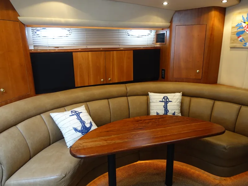 Slide: The Image of Luxurious 2001 Cruisers Yachts 4270 Express interior with curved seating and nautical decor. - 16