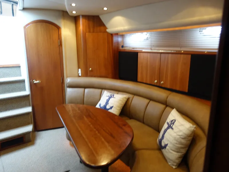 Slide: The Image of Interior of 2001 Cruisers Yachts 4270 Express with wood table and leather seating. - 17