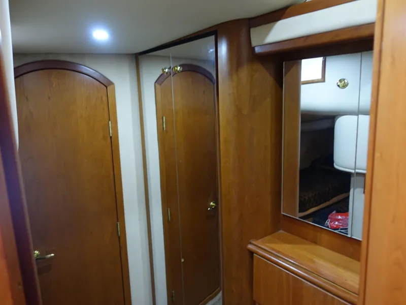 Slide: The Image of 2001 Cruisers Yachts 4270 Express interior with wooden doors and mirrored closet. - 30