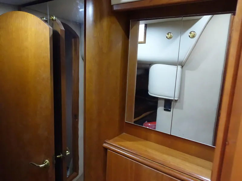 Slide: The Image of 2001 Cruisers Yachts 4270 Express interior with wooden cabinetry and mirrored closet. - 31