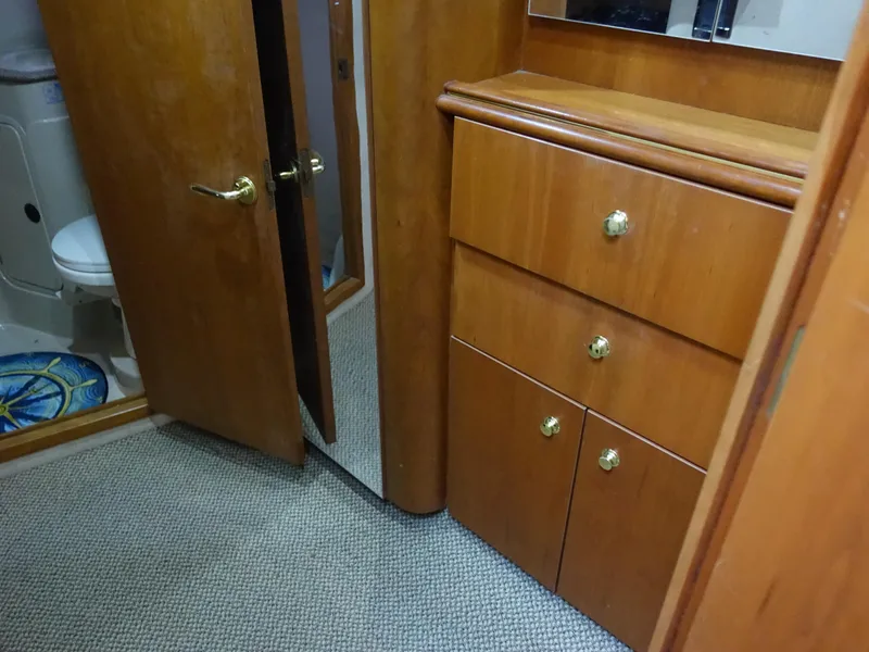 Slide: The Image of 2001 Cruisers Yachts 4270 Express interior with wooden cabinets and bathroom view. - 32