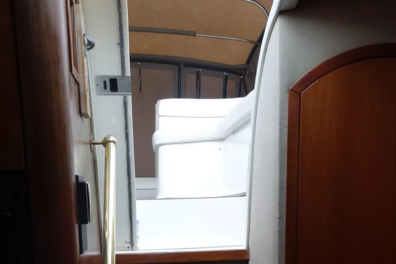 Slide: The Image of Interior view of 2001 Cruisers Yachts 4270 Express, featuring white seating and wooden accents. - 37