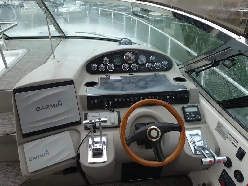 Slide: The Image of 2001 Cruisers Yachts 4270 Express helm with Garmin navigation system and wooden steering wheel. - 9