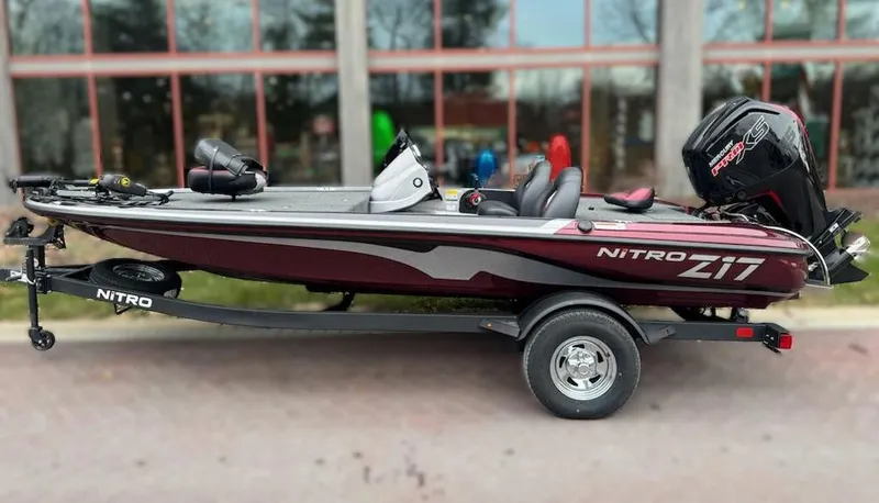 Slide: The Image of 2025 Nitro Z17 boat with trailer, maroon and gray design, parked outdoors. - 0