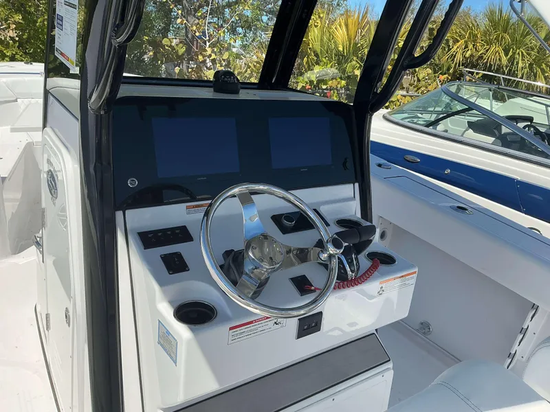 Slide: The Image of 2025 Sportsman 261 Heritage boat dashboard with steering wheel and dual screens. - 10