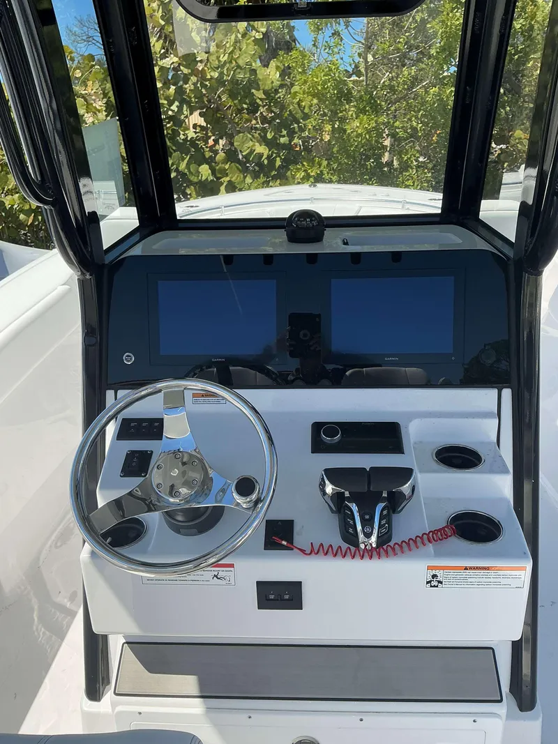 Slide: The Image of 2025 Sportsman 261 Heritage boat dashboard with steering wheel and dual screens. - 18