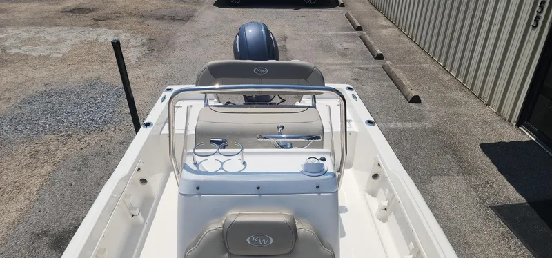 Slide: The Image of 2024 Key West 1720CC boat interior with seating and console, parked outdoors. - 13
