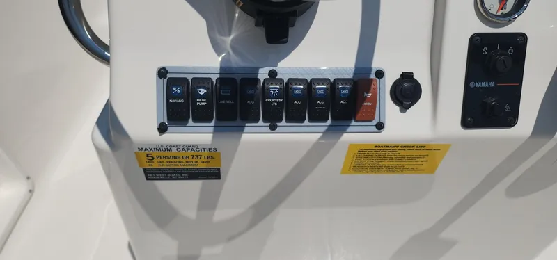 Slide: The Image of Key West 1720CC 2024 boat dashboard with control switches and capacity label. - 23