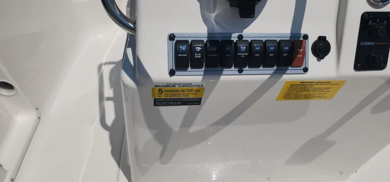 Slide: The Image of 2024 Key West 1720CC boat dashboard with capacity label and control switches. - 30