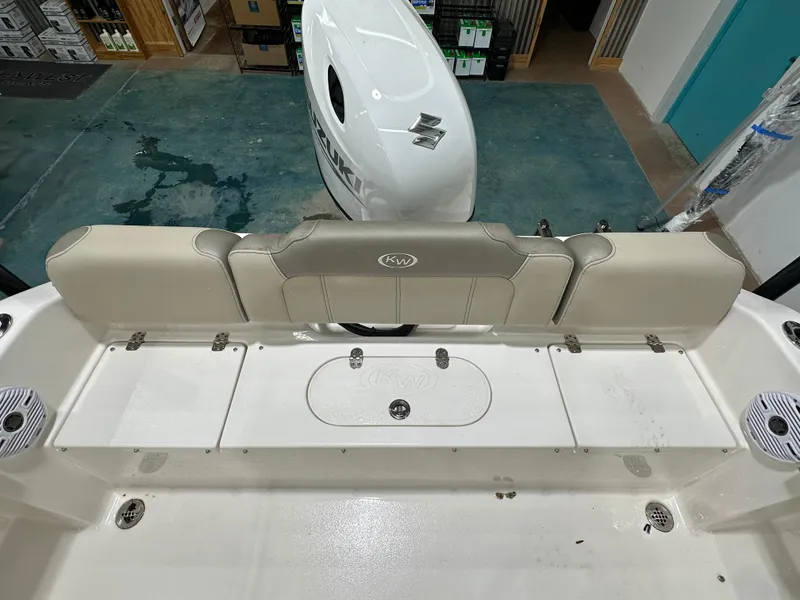 Slide: The Image of 2024 Key West 189FS boat interior with Suzuki engine, beige seating, and storage compartments. - 13