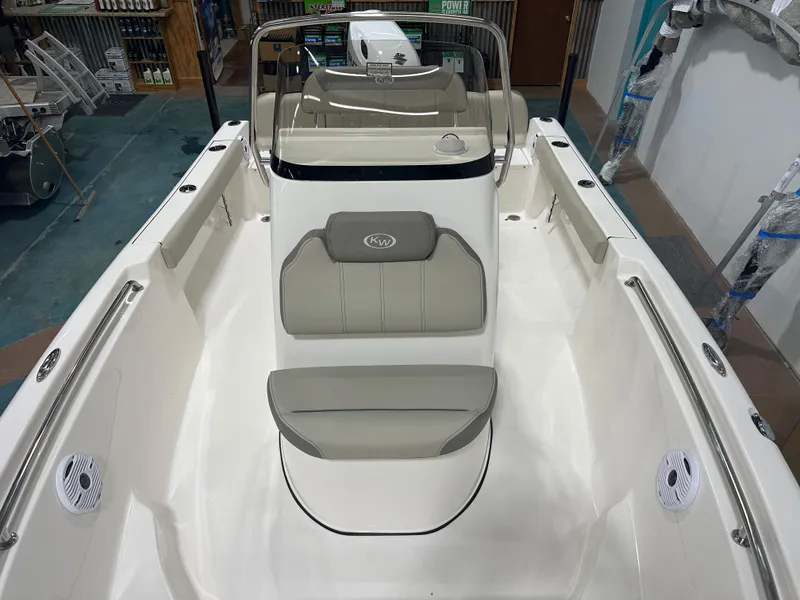 Slide: The Image of 2024 Key West 189FS boat interior with seating and console in showroom. - 28
