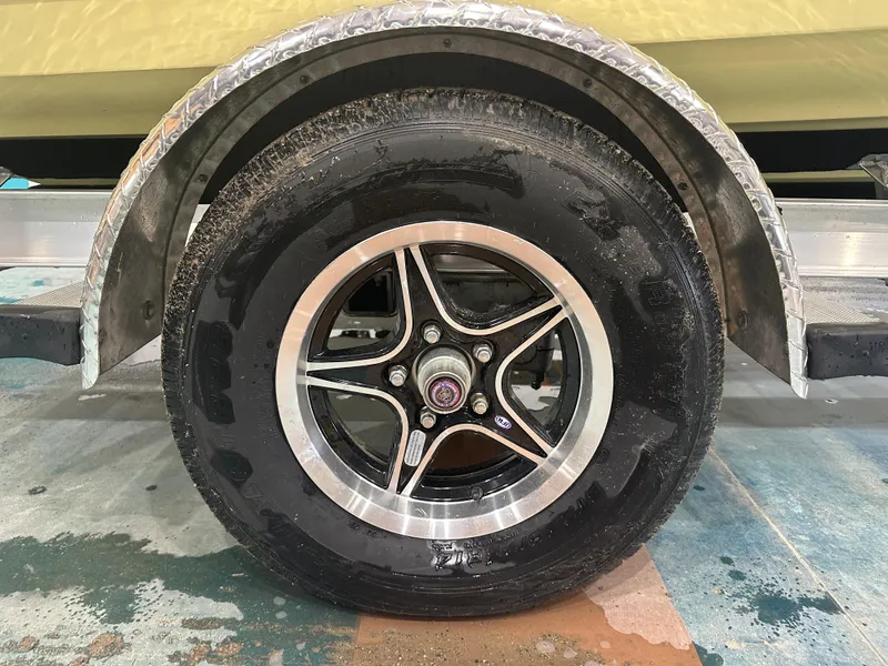 Slide: The Image of 2024 Key West 189FS trailer wheel with black tire and silver rim. - 7