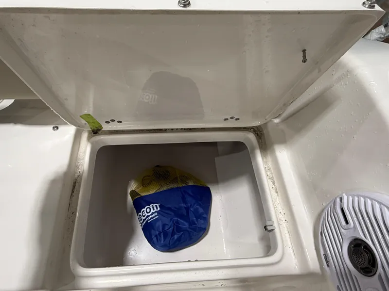 Slide: The Image of Open storage compartment on 2025 Key West 189FS boat with a blue bag inside. - 11