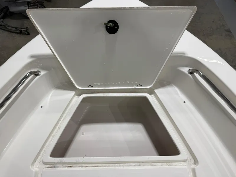 Slide: The Image of Open storage compartment on 2025 Key West 189FS boat, featuring stainless steel handles. - 18