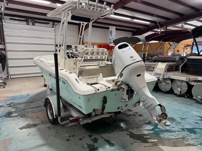 Slide: The Image of 2025 Key West 189FS boat in showroom, featuring outboard motor and trailer. - 7