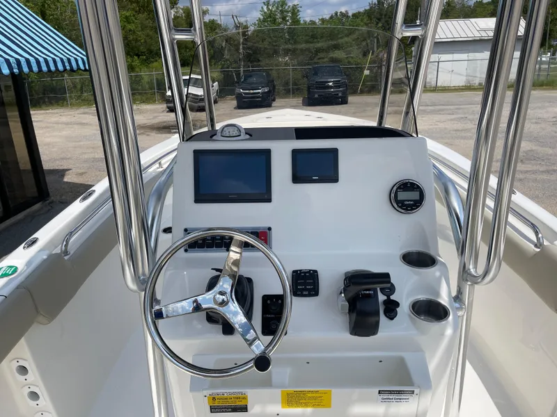 Slide: The Image of 2025 Key West 203FS boat dashboard with steering wheel and navigation screens. - 11