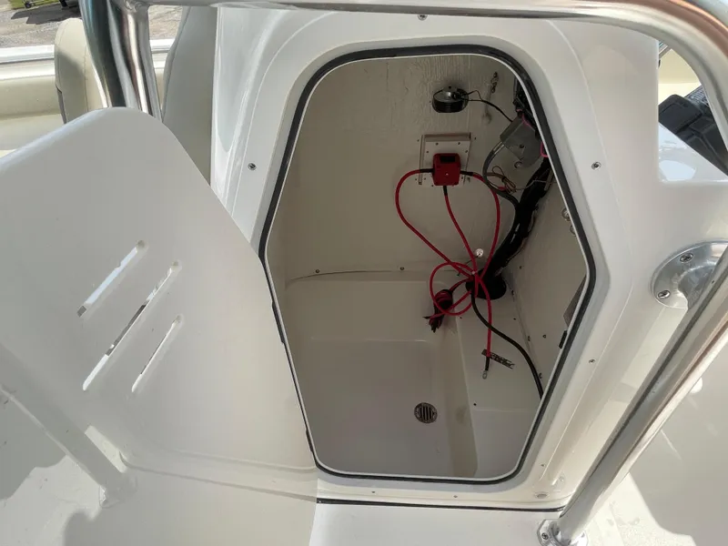 Slide: The Image of Open storage compartment in 2025 Key West 203FS boat with visible wiring. - 19