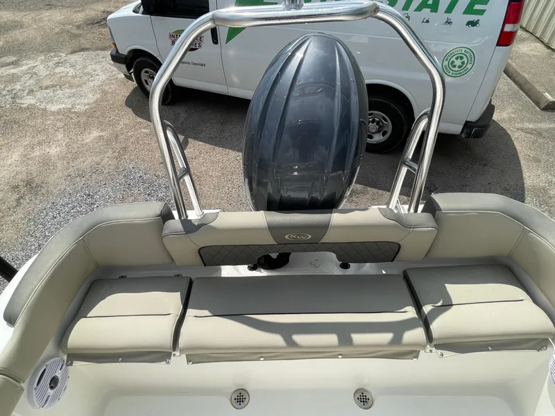 Slide: The Image of 2025 Key West 203FS boat interior with seating and engine, parked near a van. - 20