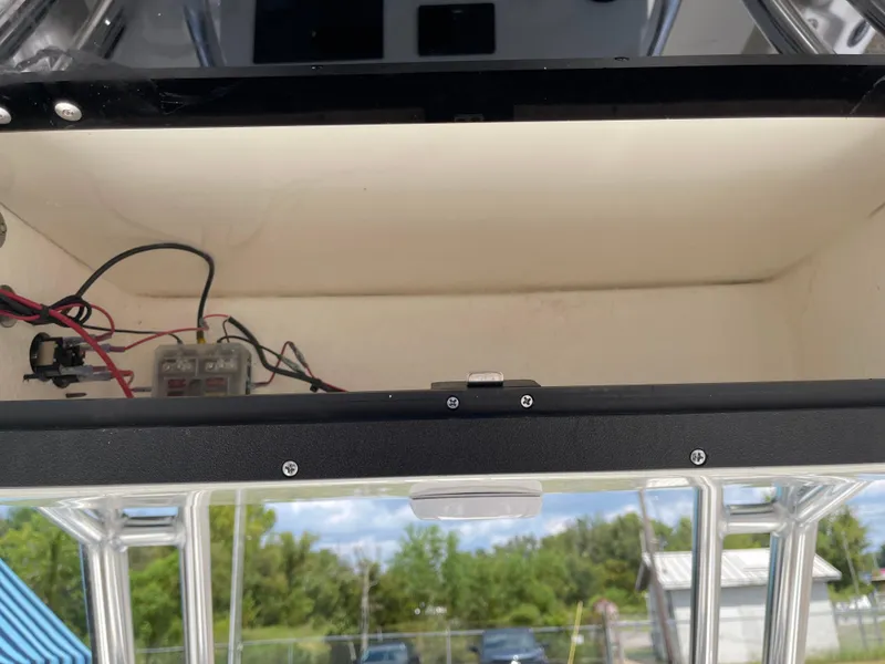 Slide: The Image of Open storage compartment in 2025 Key West 203FS boat, showing wiring and components. - 31