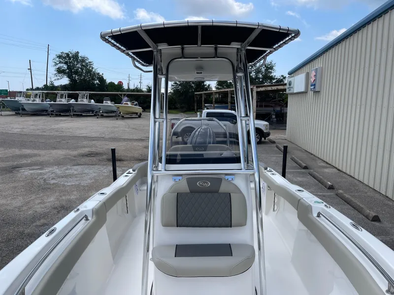 Slide: The Image of 2025 Key West 203FS boat with T-top, parked outdoors near other boats. - 35