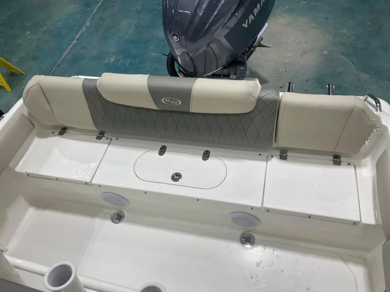 Slide: The Image of 2025 Key West 219fs boat interior with Yamaha engine, featuring cushioned seating and storage compartments. - 15