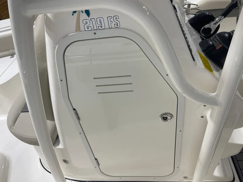 Slide: The Image of Key West 219fs 2025 boat console with storage compartment and steering wheel. - 22