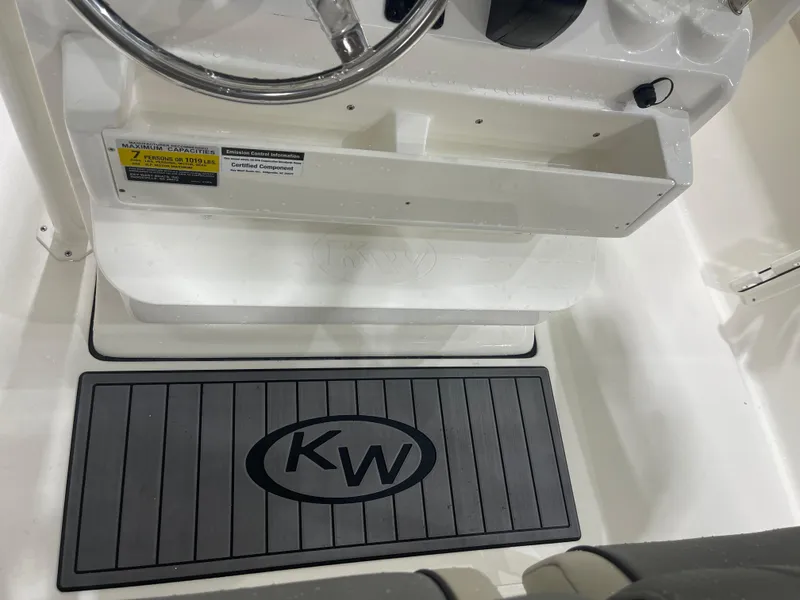 Slide: The Image of 2025 Key West 219fs boat interior with steering wheel and branded floor mat. - 26