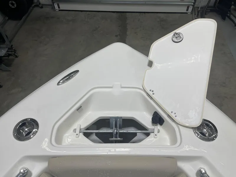 Slide: The Image of 2025 Key West 219fs boat anchor compartment with open hatch in a garage setting. - 34