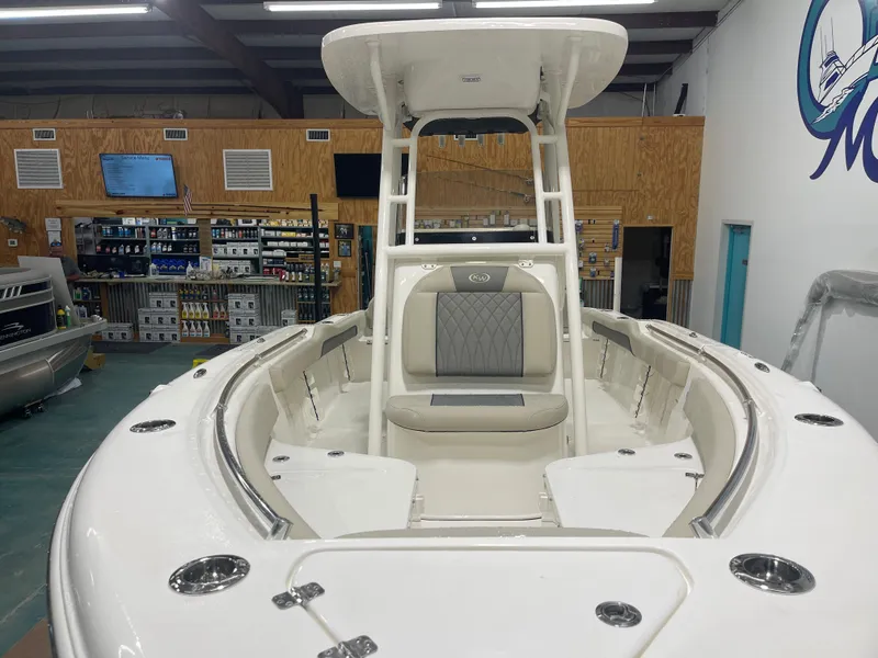 Slide: The Image of 2025 Key West 219fs boat interior in showroom, featuring seating and storage. - 9