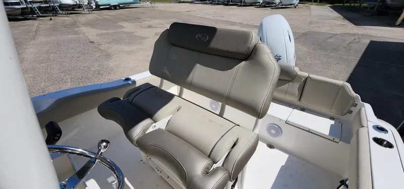 Slide: The Image of 2024 Key West 219fs boat interior with beige seating and steering wheel. - 25