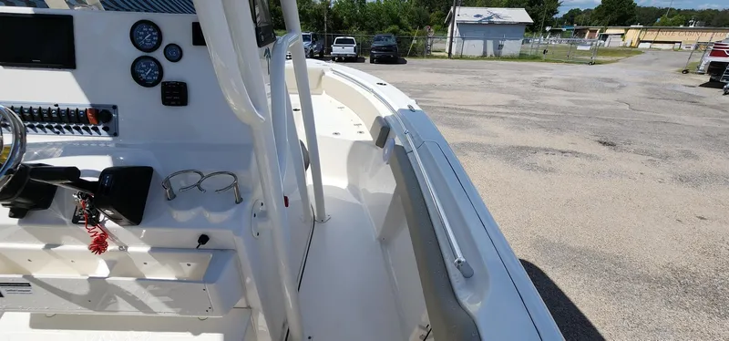 Slide: The Image of 2024 Key West 219fs boat interior with steering console and gauges, parked outdoors. - 27