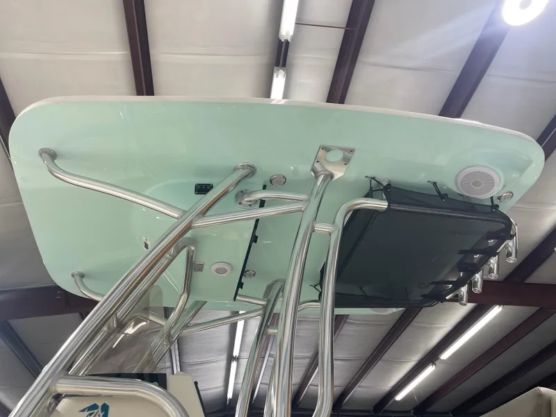 Slide: The Image of 2024 Key West 244CC boat T-top with speakers and rod holders in a showroom. - 12