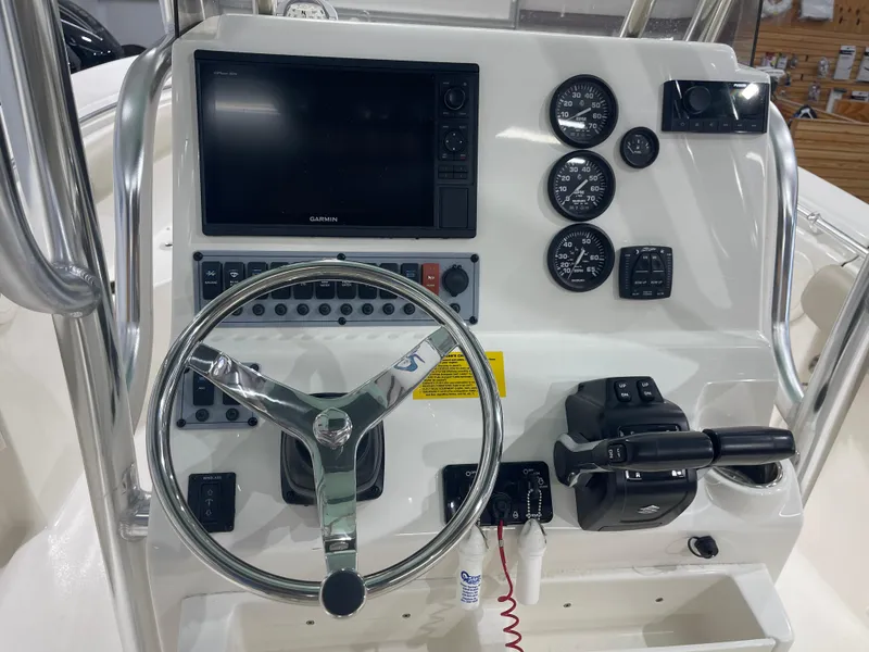 Slide: The Image of 2024 Key West 244CC boat dashboard with steering wheel, gauges, and Garmin display. - 23