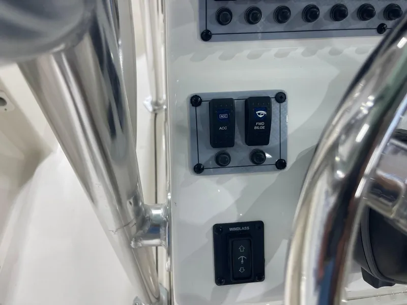Slide: The Image of 2024 Key West 244CC boat dashboard with control switches and steering wheel. - 24