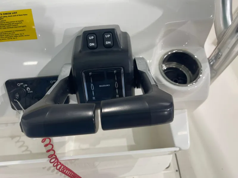Slide: The Image of 2024 Key West 244CC boat throttle controls with Suzuki branding and cup holder. - 27