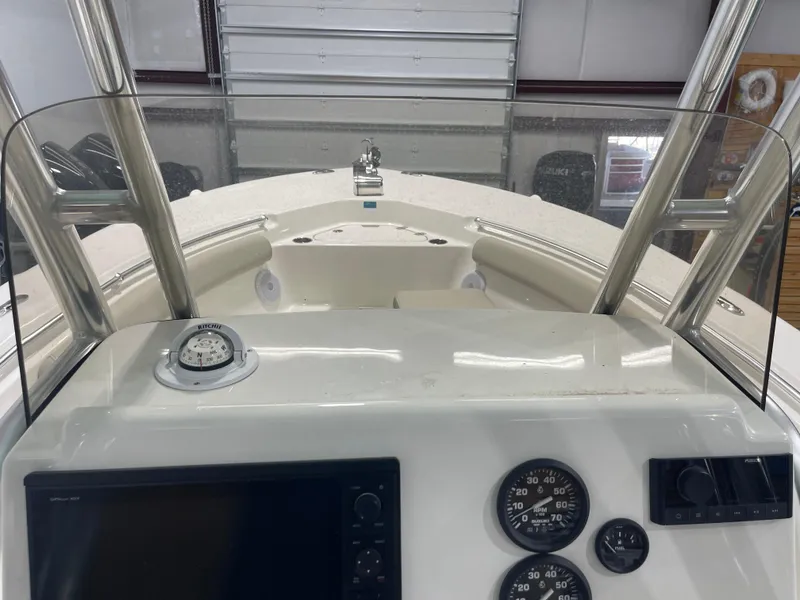 Slide: The Image of 2024 Key West 244CC boat dashboard with compass and gauges in a garage setting. - 31
